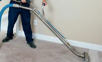 Professional operating a liquid removal machine on a carpeted floor in Cedar Rapids, IA
